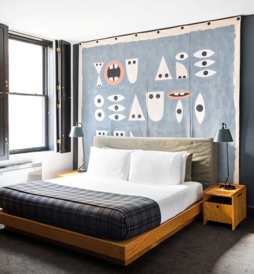 An ornate room with a colorful background and neatly folded bed.