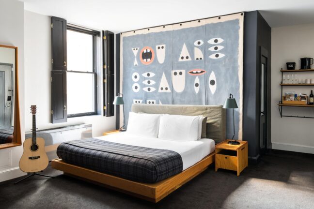 An ornate room with a colorful background and neatly folded bed.